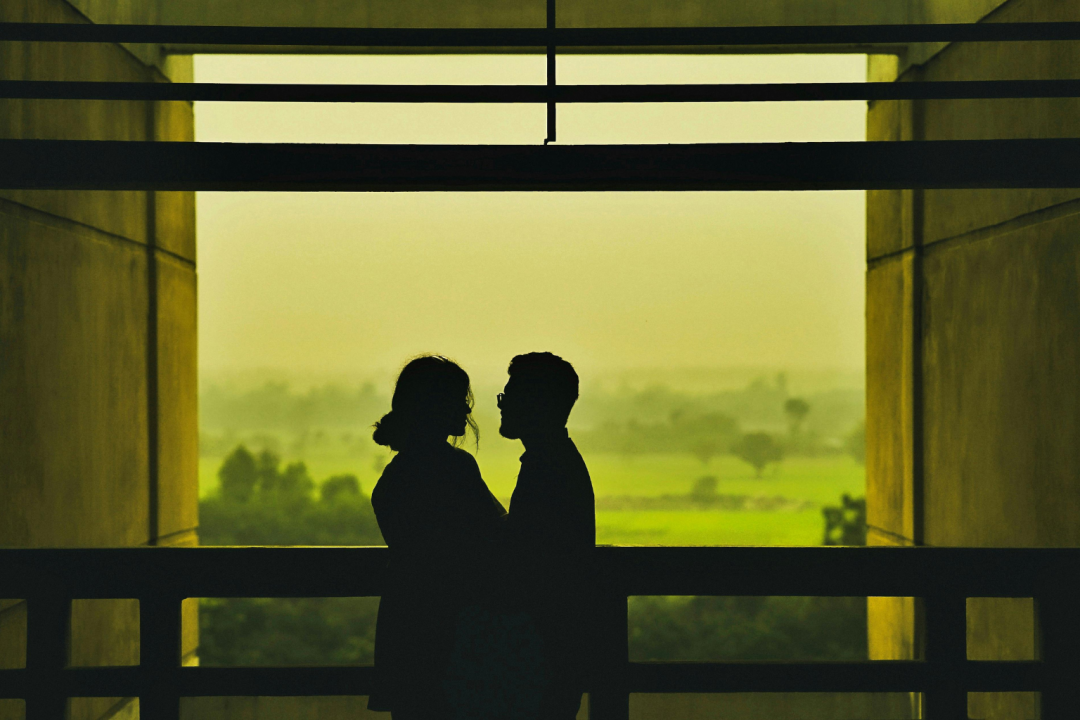 Couple embracing in silhouette overlooking a green landscape, representing second chance romance books and rekindled love